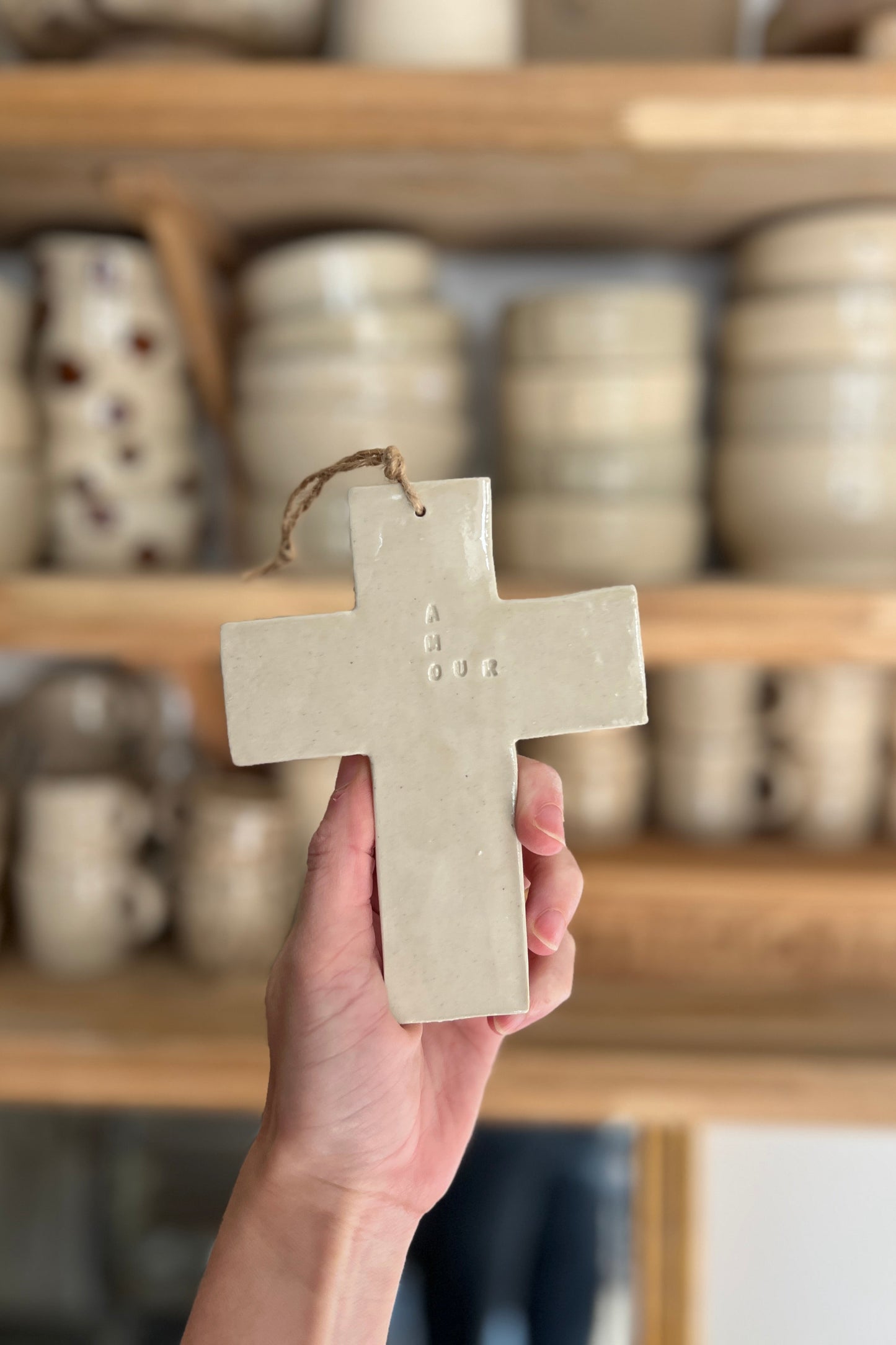 croix épurée en céramique avec l'inscription amour gravée faite à la main a Montpellier en poterie