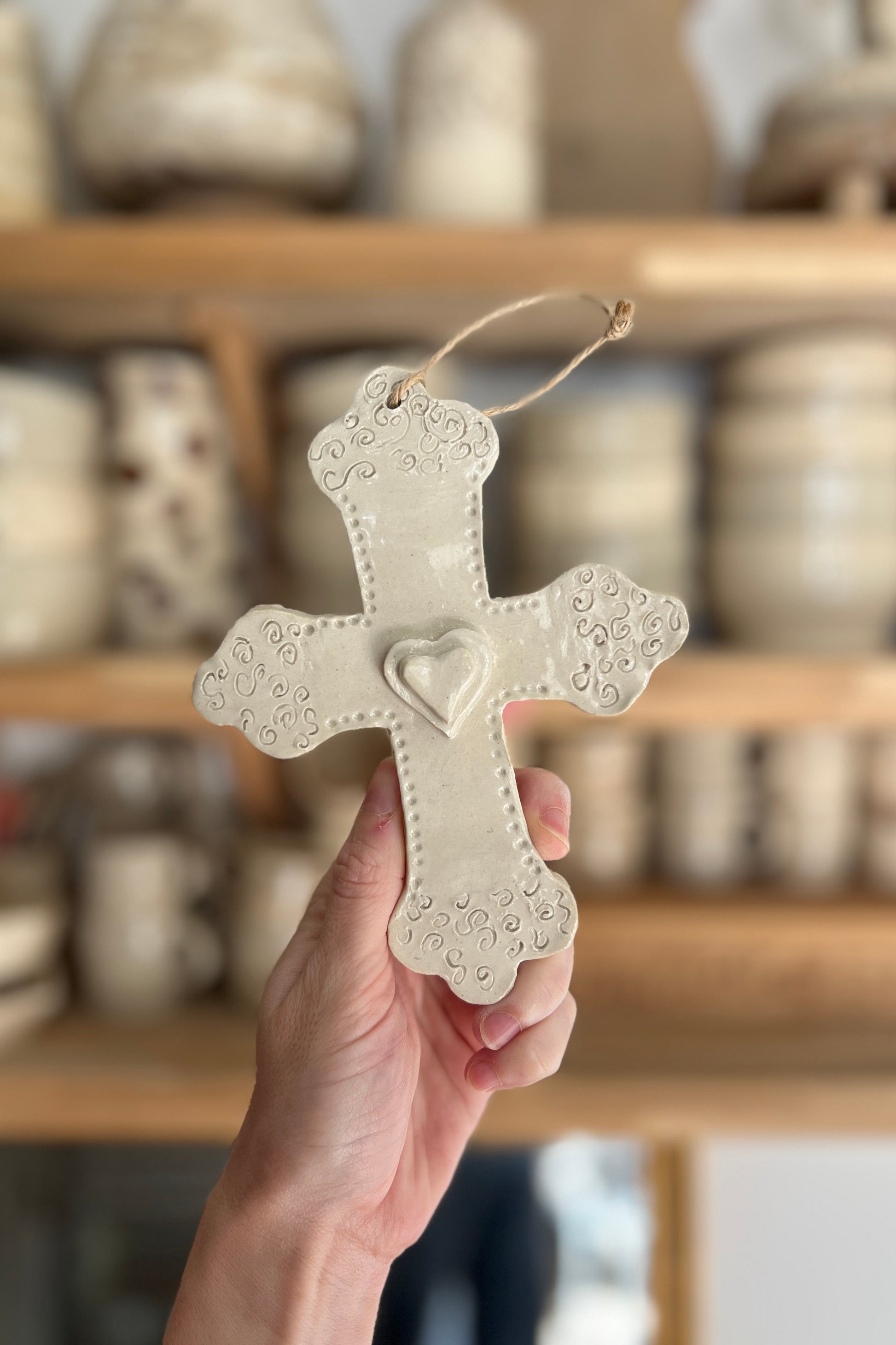croix en céramique argile émaillée réalisée a la main martelée et avec un coeur en relief au centre. faite dans un atelier de poterie de Montpellier