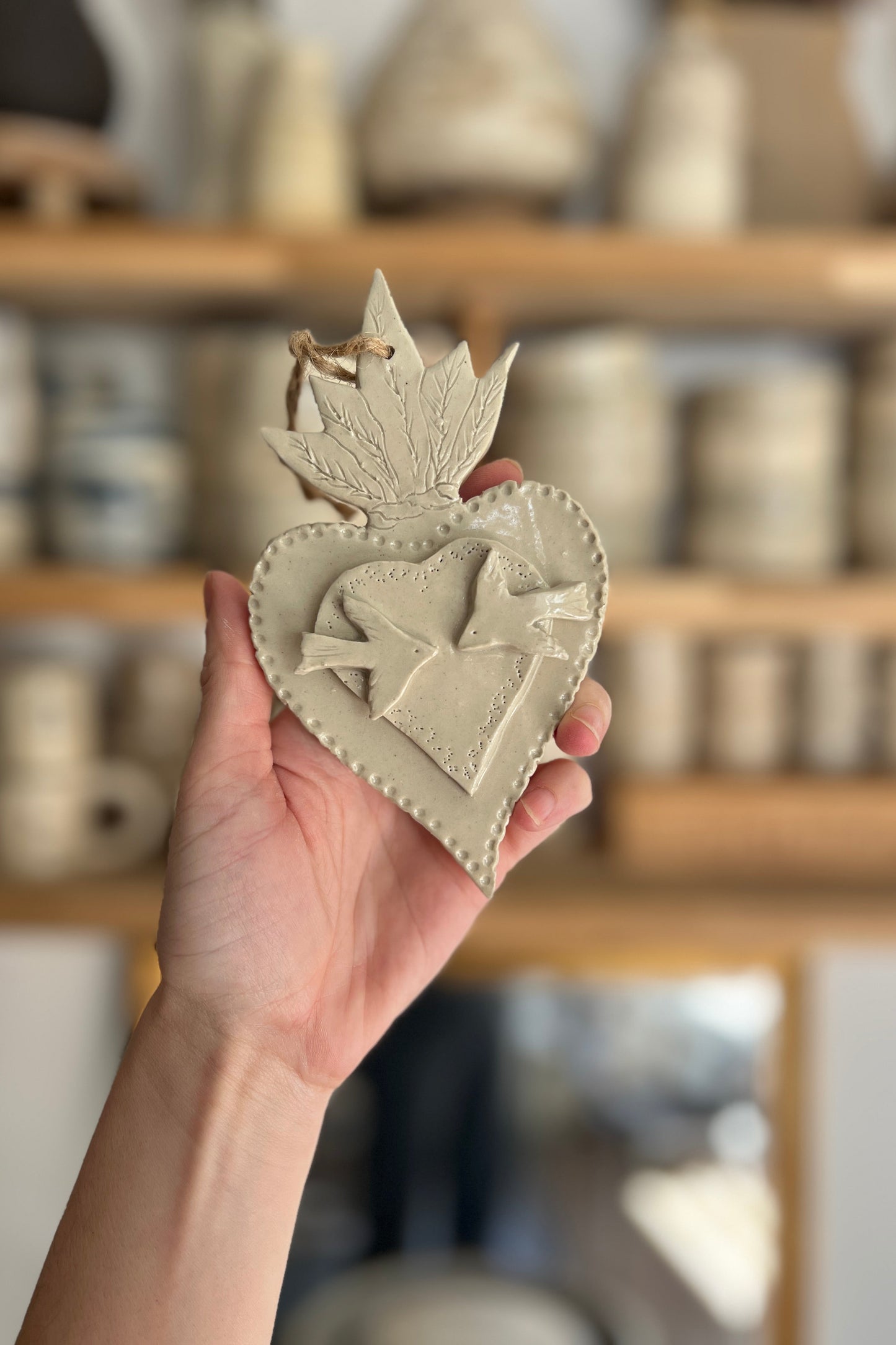 ex voto ou coeur sacré artisanal représentant deux oiseaux dans un coeur en relief réalisé dans un atelier de poterie à Montpellier 