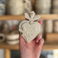 petit coeur sacré ou ex voto avec un oiseau et des détails martelés sur le coeur réalisé a la main dans un atelier artisanal de poterie près de Montpellier à baillargues